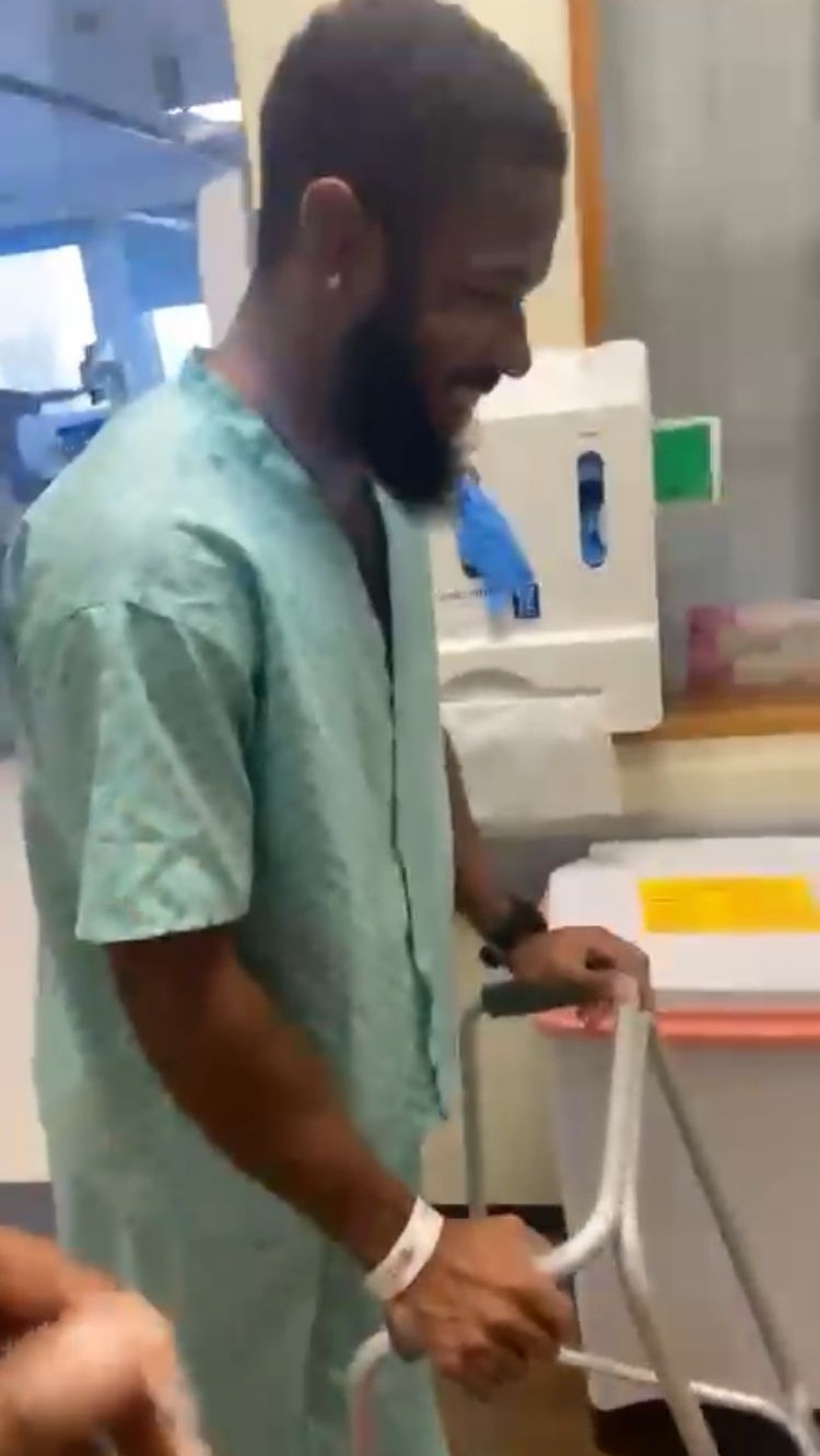 Ryan Compass recovering in hospital, walking with a frame
